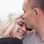 man kissing woman's forehead